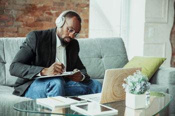 Man taking notes with his headphones on
